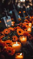 Beautiful arrangement of orange flowers and candles at a grave during evening hours photo