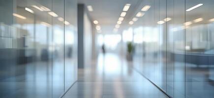 Modern office interior featuring glass walls and a blurred figure in a spacious hallway photo