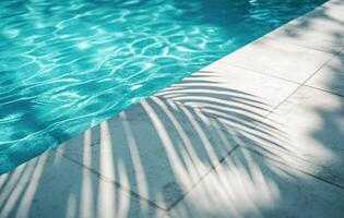Beautiful sunlight reflections on a swimming pool with palm tree shadows by the edge photo