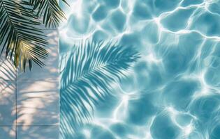 Bright sunlight reflecting in the clear blue water of a pool surrounded by palm leaves photo