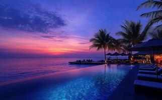 Sunset illuminates serene beachfront pool at tropical resort during evening twilight photo