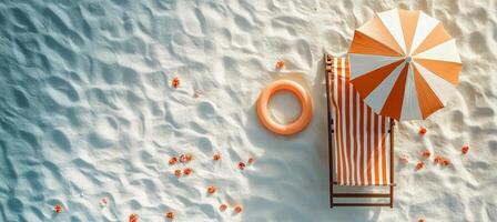 Relaxing beach setup with a striped umbrella and lounge chair on a sandy shore photo