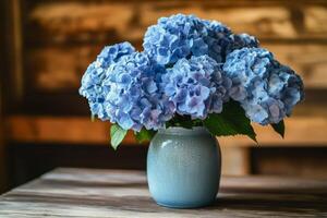 A blue vase with some blue flowers sitting on a table photo