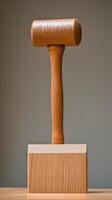A hammer on a wooden block with a wooden handle photo