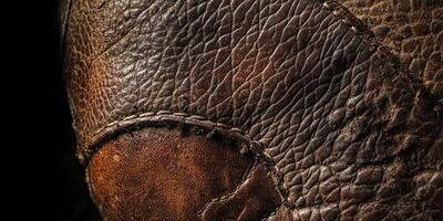 Macro view of textured brown leather showing seams and detail photo