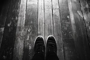 Black and white image of person standing on wooden floor photo