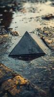 A puddle of water on the ground with a pyramid photo