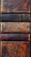 Stack of aged leather bound books showing wear and patina photo