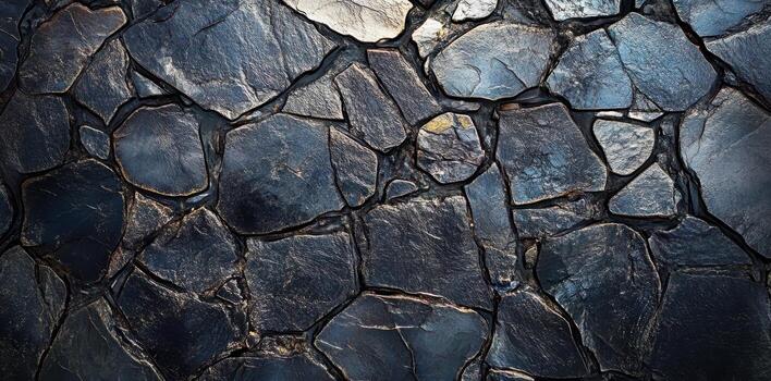 Dark stone wall features uneven and irregularly shaped elements photo