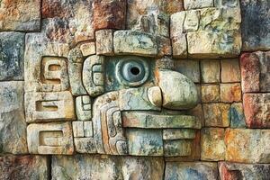 Stone carving of a face on ancient mayan architecture photo