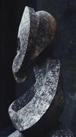 Abstract stone sculpture with hollow face and curving body photo