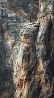 Man standing on a rocky cliff overlooking a mountain range photo