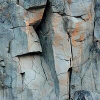 Fragmented rock face with cracks and subtle color variations photo