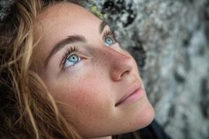 Young woman with freckles looks up towards a hopeful future photo
