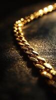 Close up showcases a glistening gold chain on dark surface photo