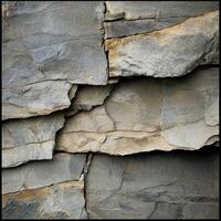 Gray and tan stone wall with layered and textured surfaces photo