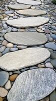 Flat stones form a walkway surrounded by smooth pebbles photo