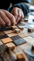 Hands moving a wooden piece on a checkerboard surface photo