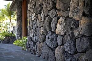 An exterior wall constructed from rough textured stones is visible photo