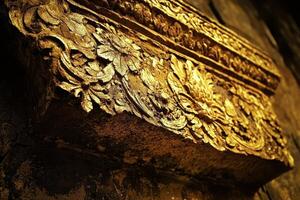 Intricate golden floral carvings adorn a decorative architectural element photo