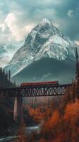 A train crossing a bridge over a river with mountains in the background photo