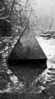 A black and white photo of a pyramid sitting on the ground