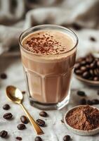 Delicious coffee drink topped with cocoa powder in glass with coffee beans and cocoa powder nearby photo