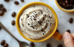 Delicious whipped cream topped coffee served in a vibrant yellow mug with chocolate sprinkles photo