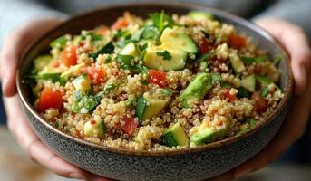 Quinoa salad with fresh vegetables served in a bowl on a wooden table photo