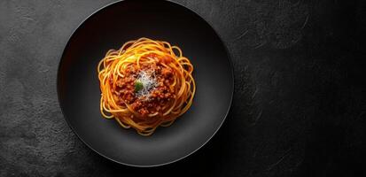 Spaghetti with meat sauce on black plate photo