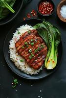 Grilled pork belly with rice and vegetables on black background photo