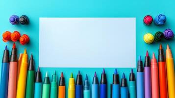 Colorful markers and blank paper on a blue background photo