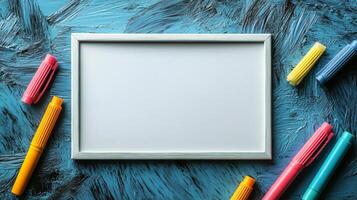 A white frame surrounded by colorful markers photo