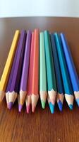 A group of colored pencils on a wooden table photo