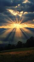 Sunbeams shining through clouds over a field photo