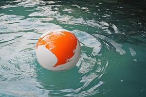 A white and orange ball floating in the water photo