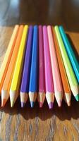 A group of colored pencils on a wooden surface photo