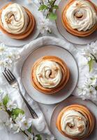 Delicious cinnamon rolls with cream cheese frosting displayed on plates with floral accents photo
