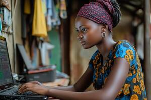 Young woman using a laptop in a vibrant traditional outfit in a cozy workspace photo