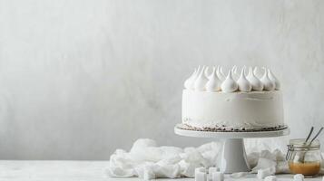 Delicious white cake topped with fluffy meringue on a simple stand in a bright setting photo