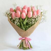 Arrangement of fresh pink tulips with baby's breath in a burlap wrap for special occasions photo