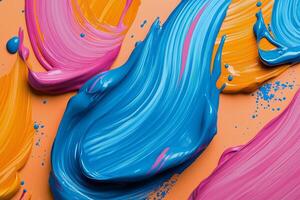 Colorful swirls of blue, pink, and orange paint on textured surface for creative artwork photo