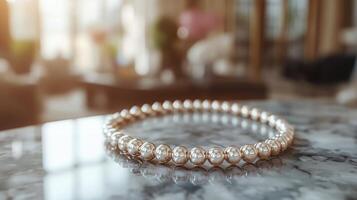 Elegant pearl necklace displayed on marble surface in warmly lit room setting photo