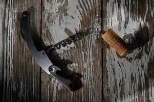 Corkscrew and cork resting on a weathered wooden surface in soft afternoon light photo