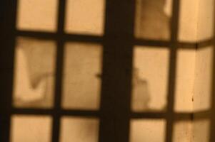 Shadows play on the walls of an old building during a warm afternoon sun photo