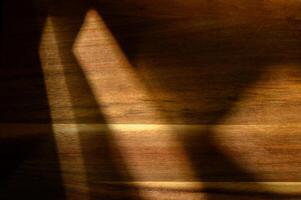 Shadows dance gracefully across a wooden surface during twilight hours, creating an enchanting ambiance photo