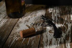 Enjoying an evening of fine wine with a corkscrew and bottle on a rustic wooden table photo