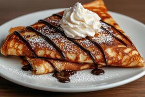 Delicious crepes with chocolate sauce and whipped cream. photo