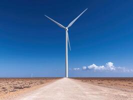 Wind turbine on a desert road generating clean energy photo