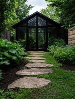 A greenhouse surrounded by lush greenery and a stone path photo